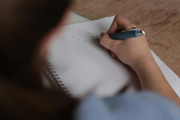 woman writing on a piece of paper with a pen