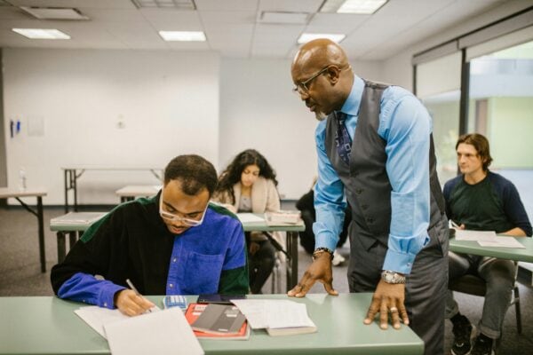professor talking to student at a desk