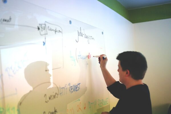 man writing on a white board