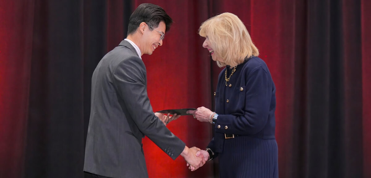 Two SIOP members shaking hands while exchanging an award
