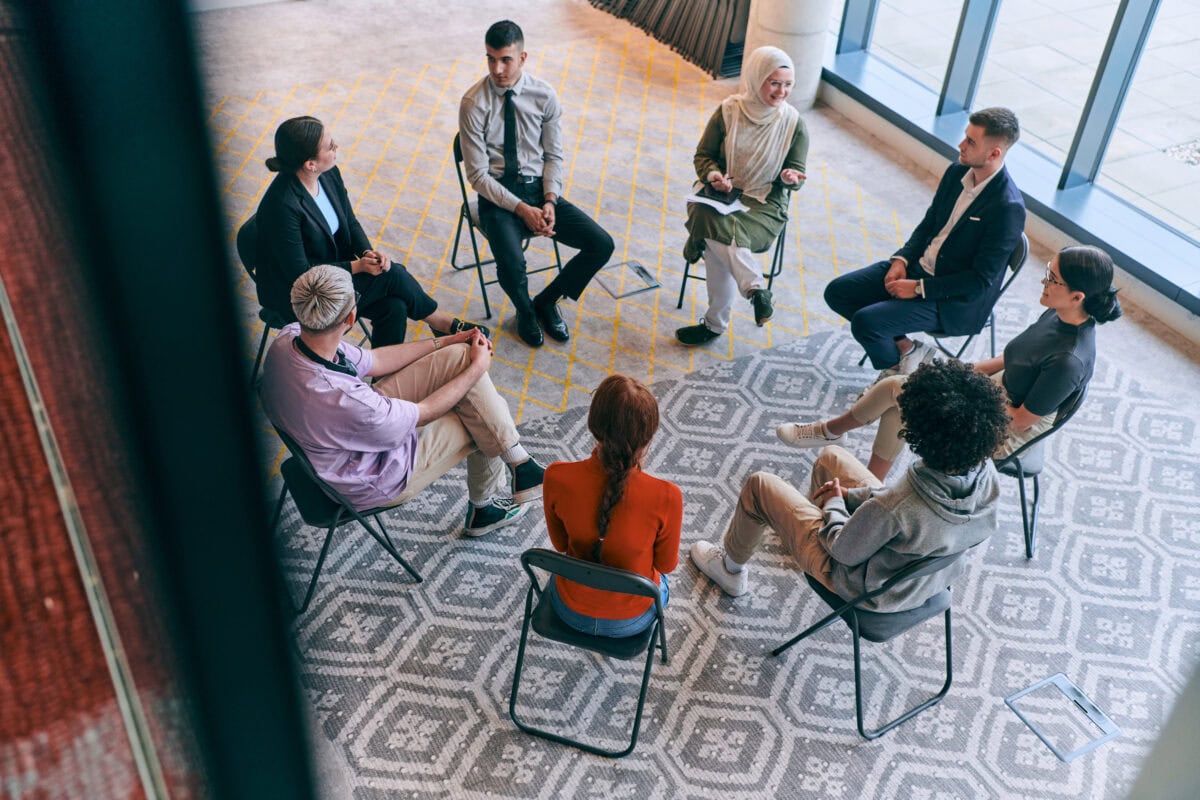 Top view of a diverse group of young business entrepreneurs gathered in a circle for a meeting.