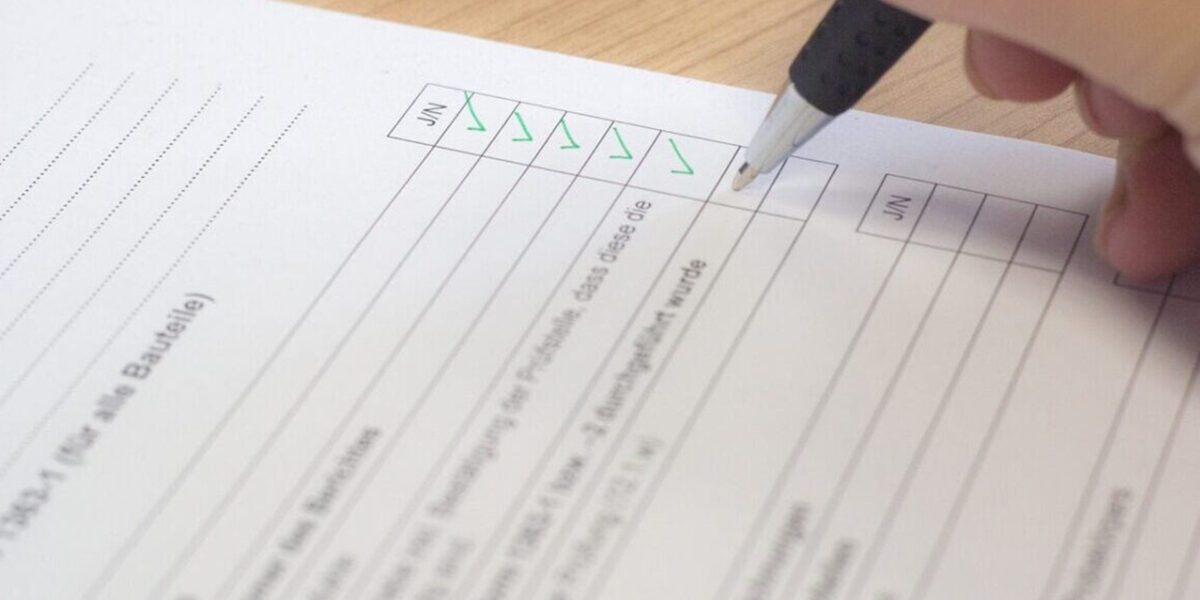 A person is writing on a paper with a pen.