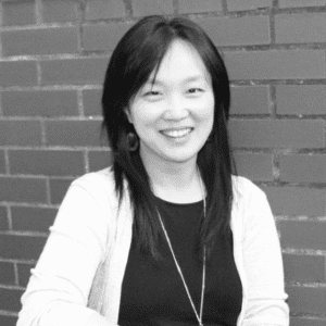 Professional black and white headshot of SIOP Fellow Sang Eun Woo standing in front of a brick wall