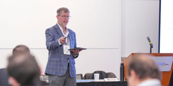 A man dressed in a suit stands at a podium, presenting to an audience at a SIOP Annual Conference.