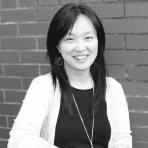 Professional black and white headshot of SIOP Fellow Sang Eun Woo standing in front of a brick wall