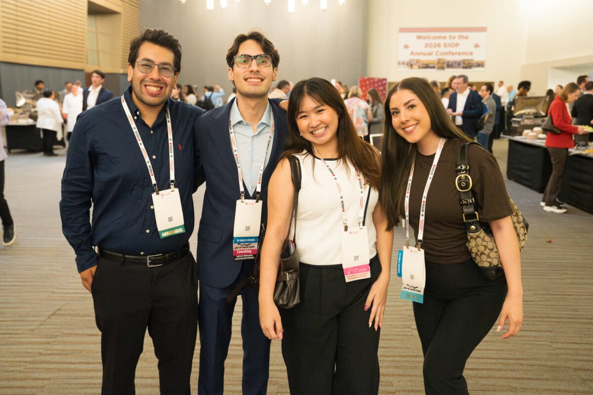 Conference attendees networking and conversing in a reception area during a SIOP event.