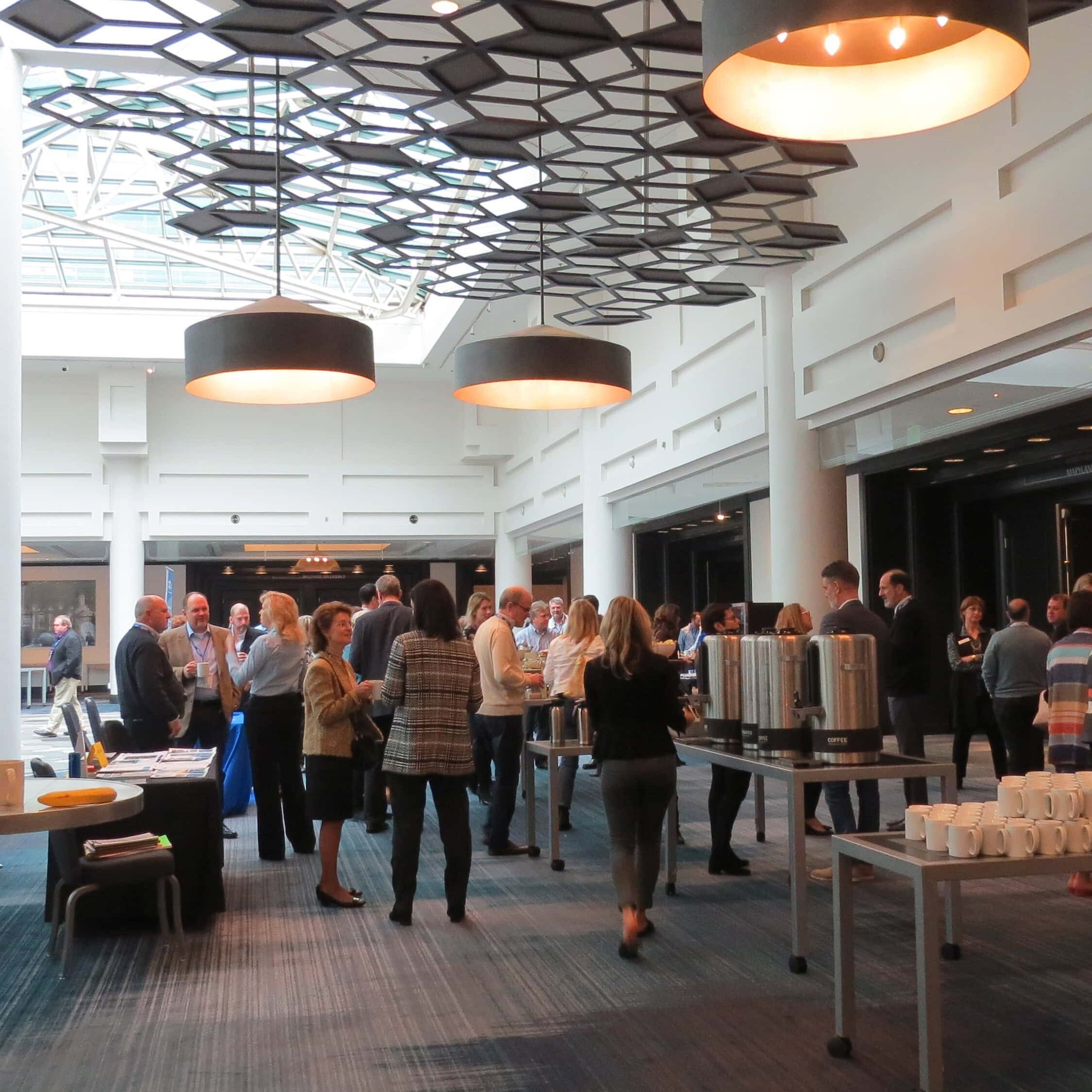 Attendees are networking at SIOP's Leading Edge Consortium in a modern, well-lit venue.