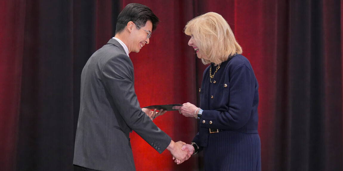 Two SIOP members shaking hands while exchanging an award