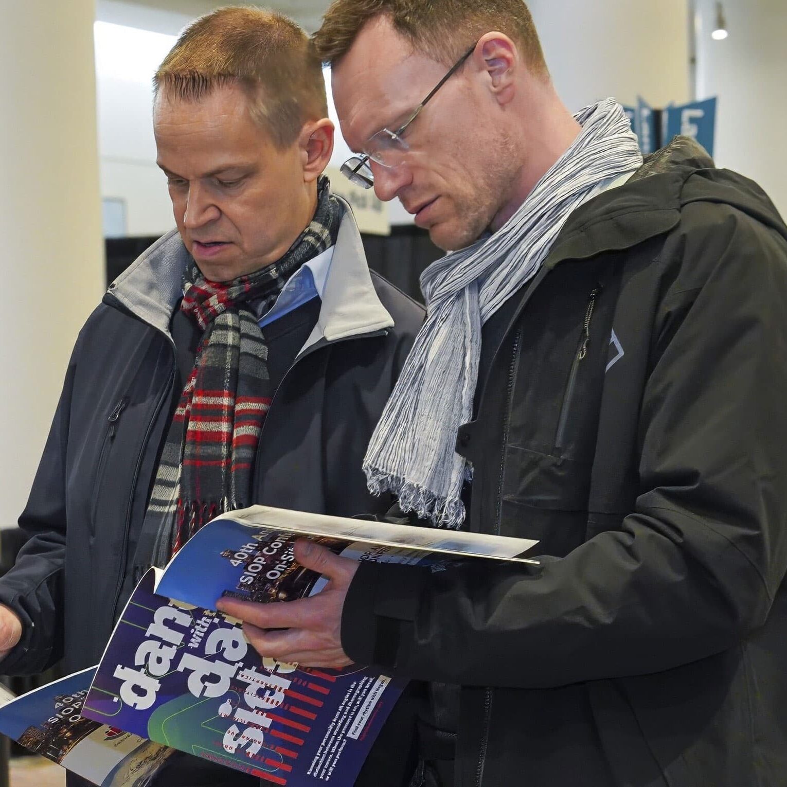Annual Conference Attendees checking the Onsite Guide while standing in the the lobby