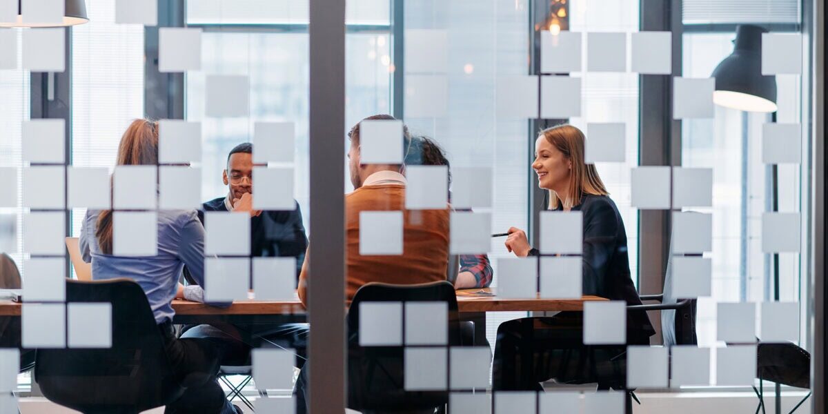 Several colleagues gathered at a conference table in an office, collaborating on a project or meeting.