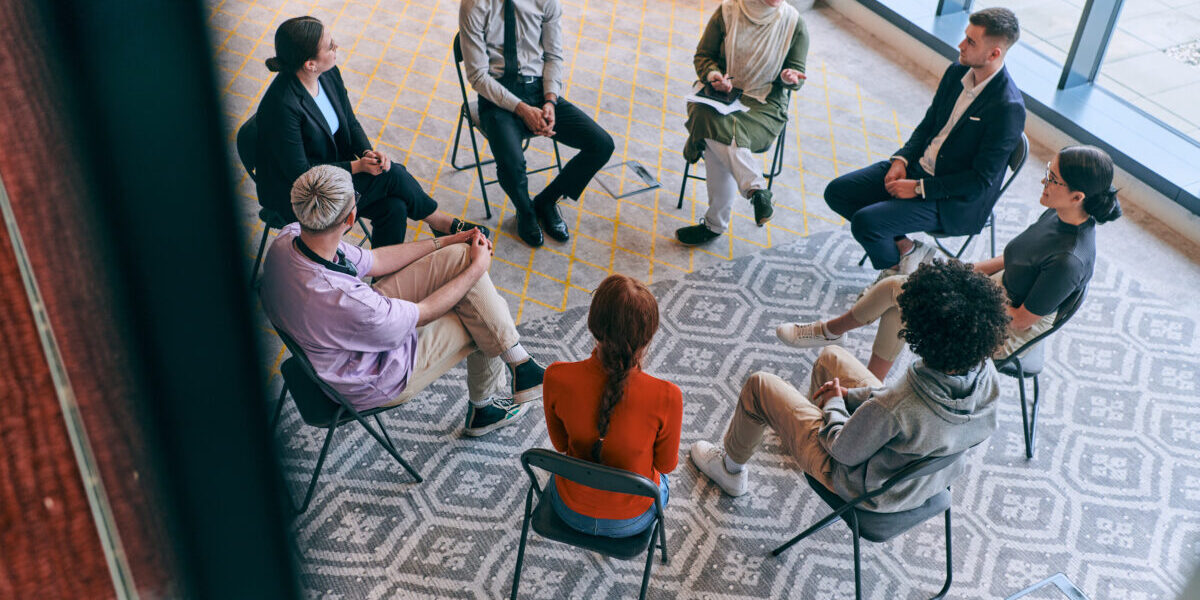 Top view of a diverse group of young business entrepreneurs gathered in a circle for a meeting.