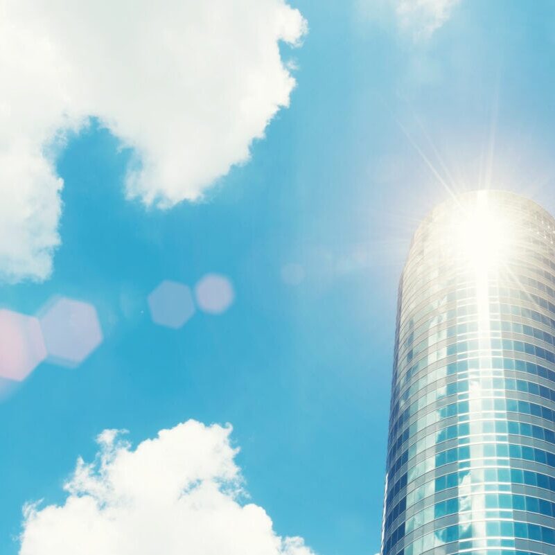 High modern building with glass with blue sky and sunlight. Busi High modern building with glass with blue sky and sunlight. Business background. Vintage filtered.