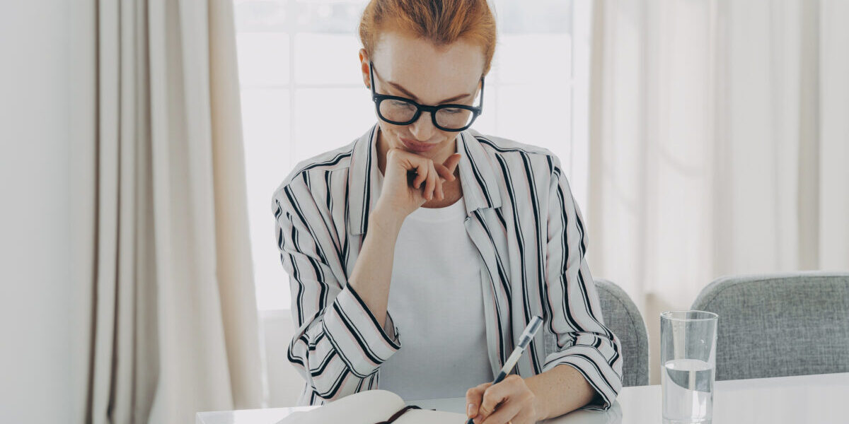 Woman in striped shirt takes notes