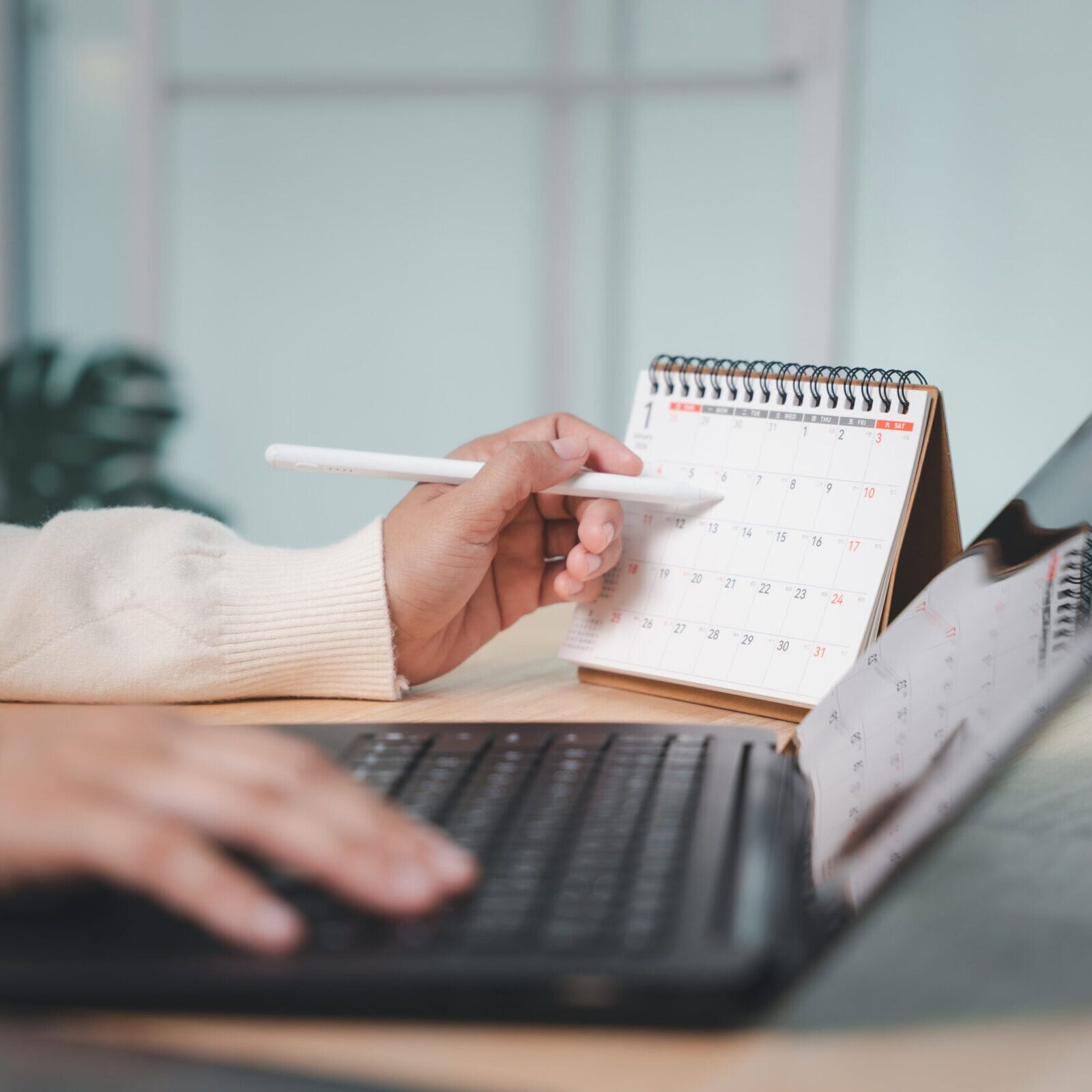 Person using pen for calendar planning to circle event time
