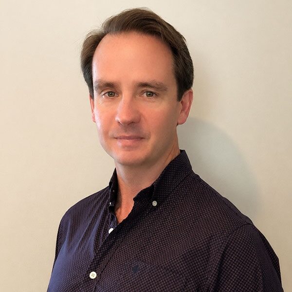 Professional man in dark shirt with Society for Industrial and Organizational Psychology logo.
