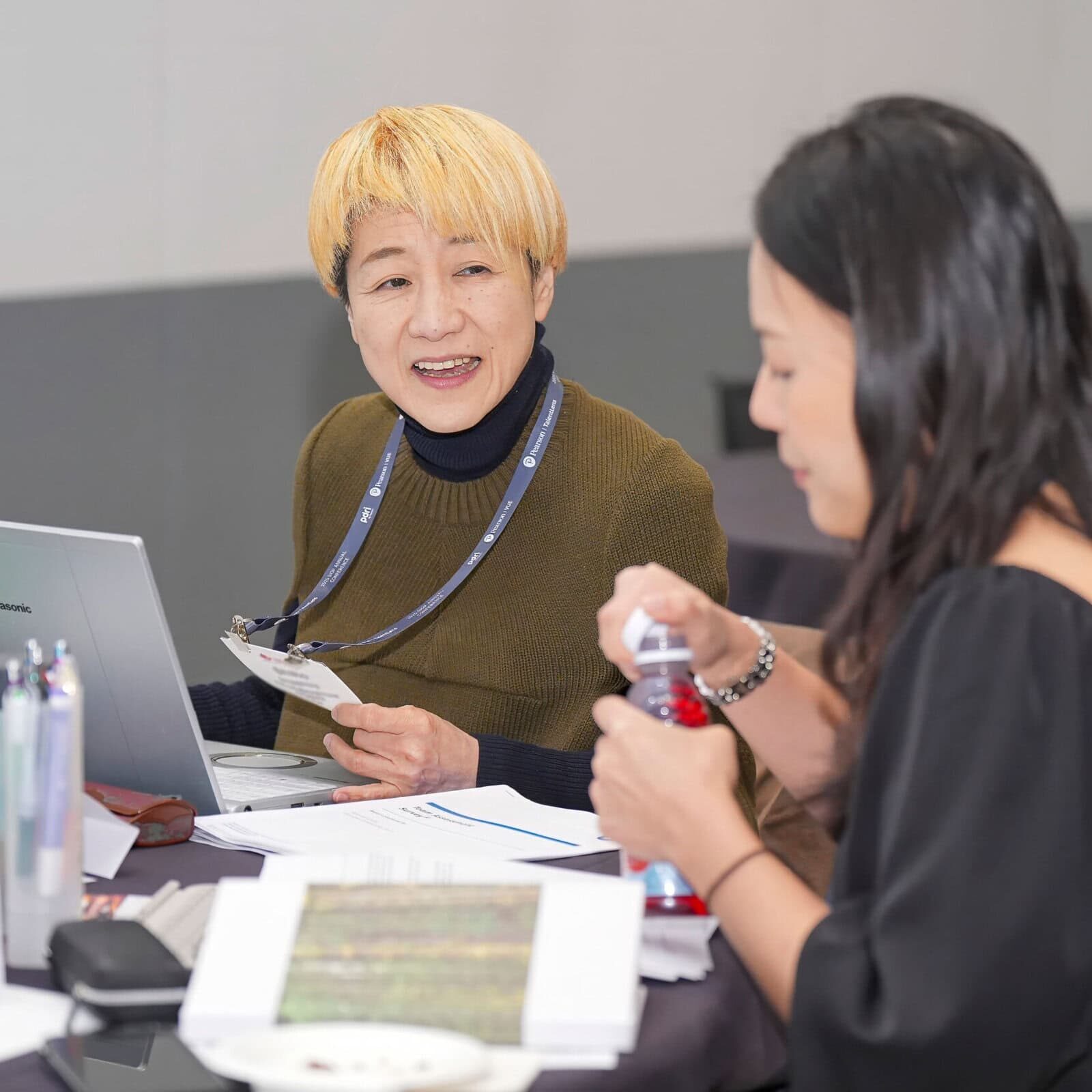 Two women engaging in discussion at a professional psychology conference.