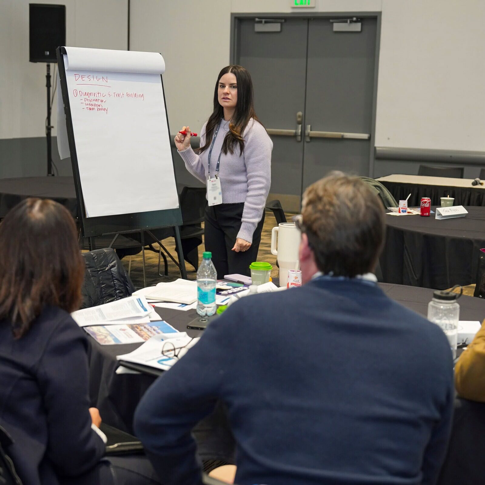 Woman presenting at SIOP conference with audience in a meeting room.