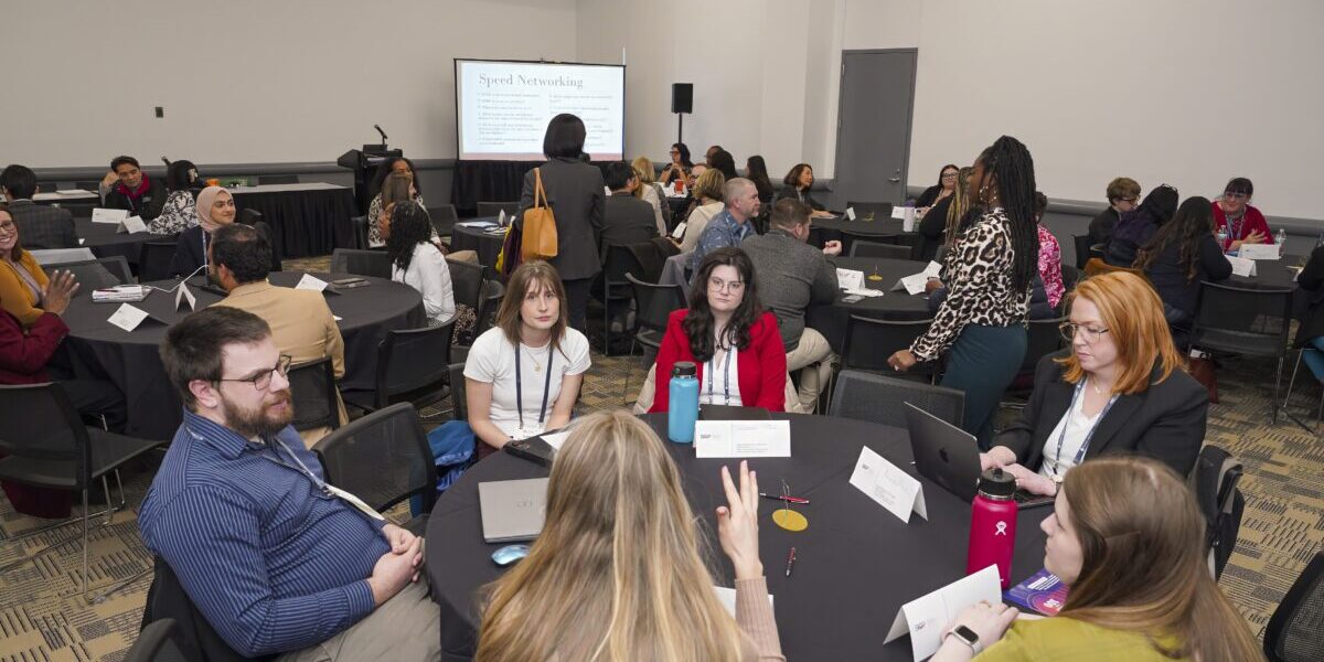 . A group of professionals seated around a table in a conference room engaged in discussion.