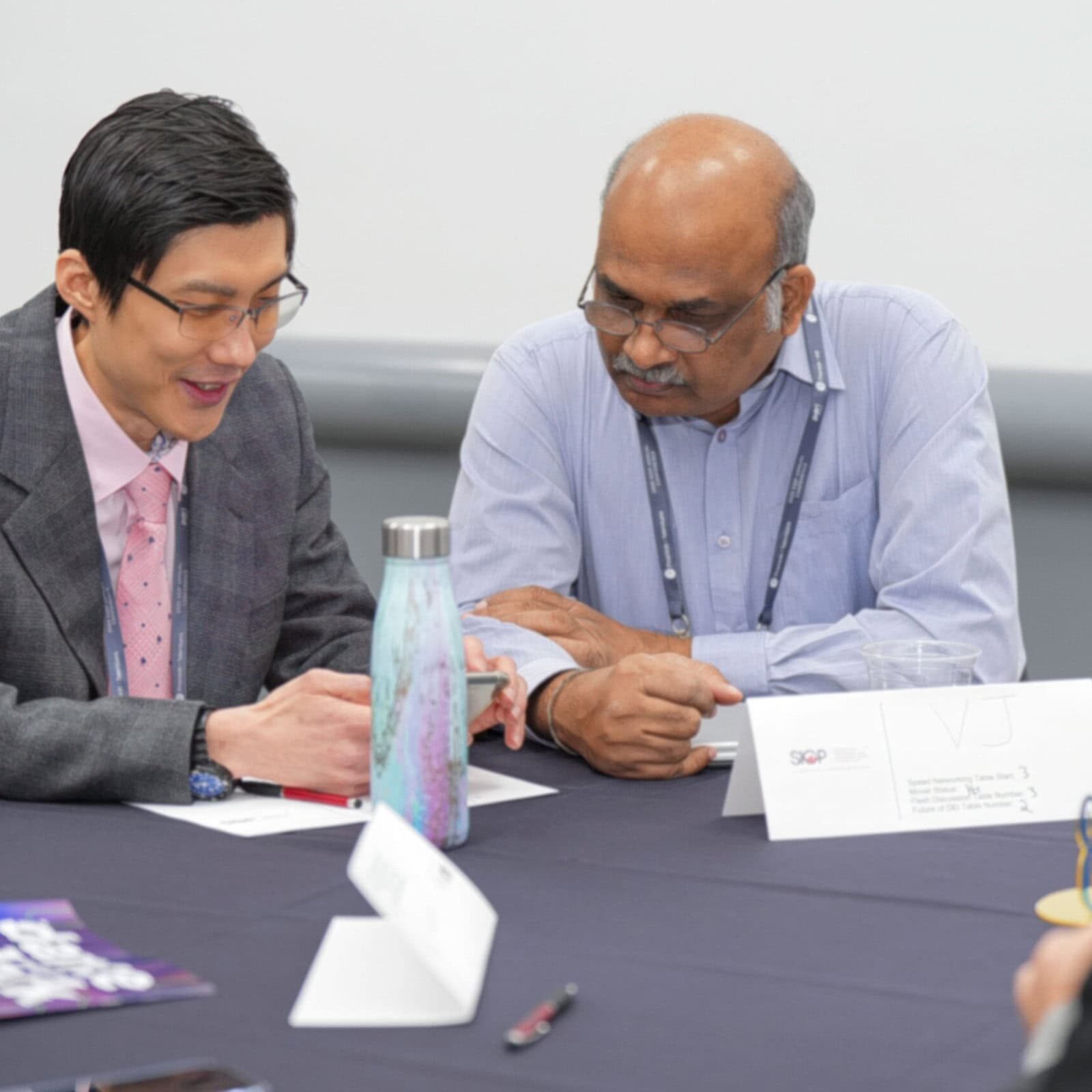 Two professionals discussing at a conference table.