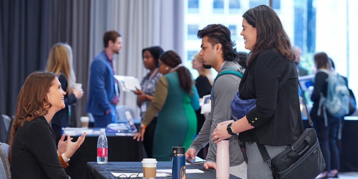 People standing around tables at the Exhibit Hall during the 2025 Annual Conference.