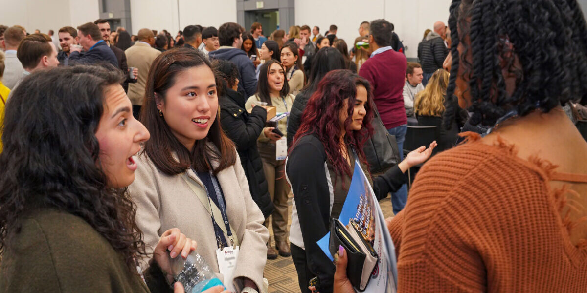 A group of people engaged in conversation, standing together in a casual setting.