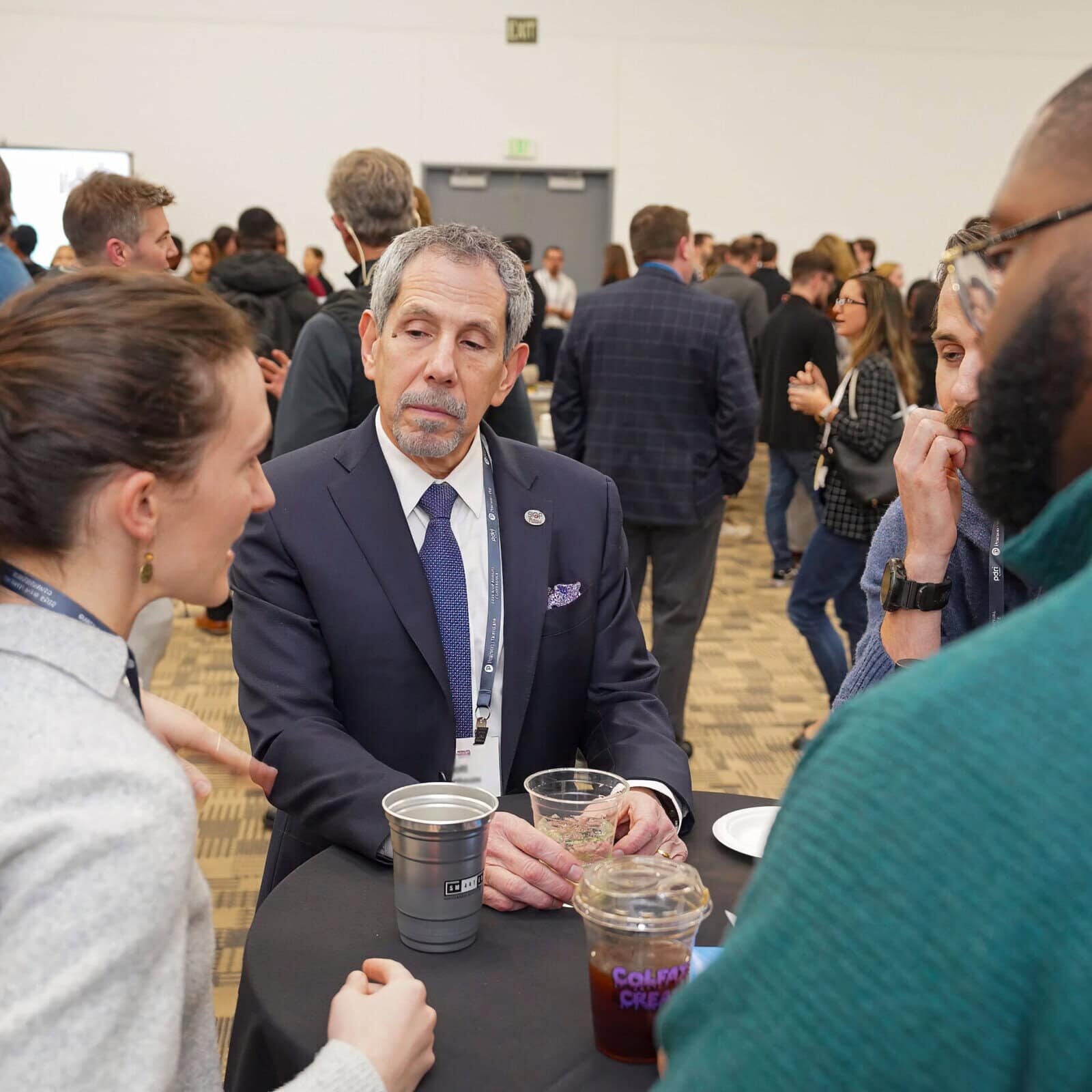 A man and woman engage in conversation with another man at a table, sharing ideas in a casual setting.