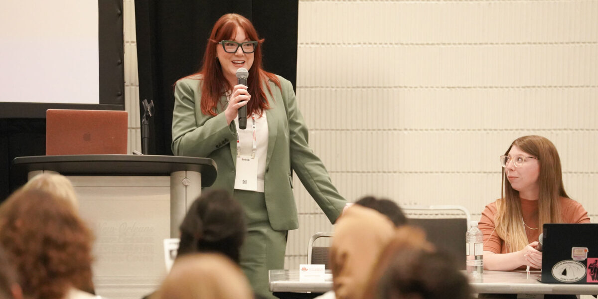 Female speaker addressing attendees during a conference session.