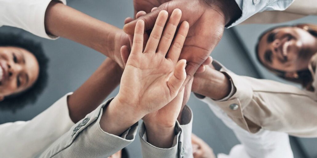 a group of people putting their hands together in a business setting