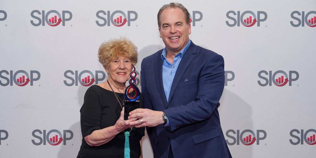 Two SIOP members standing together and holding an award