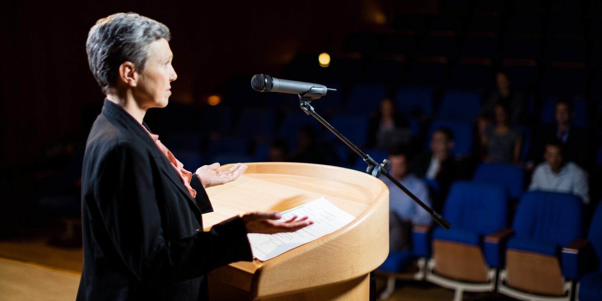 Female business executive giving a speech at conference center