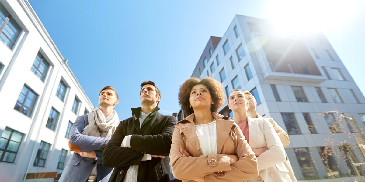 business, teamwork and leadership concept - international group of people on city street