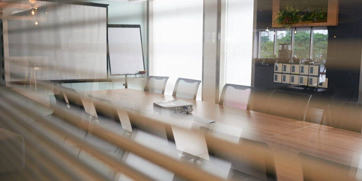 A conference room with blinds and chairs.