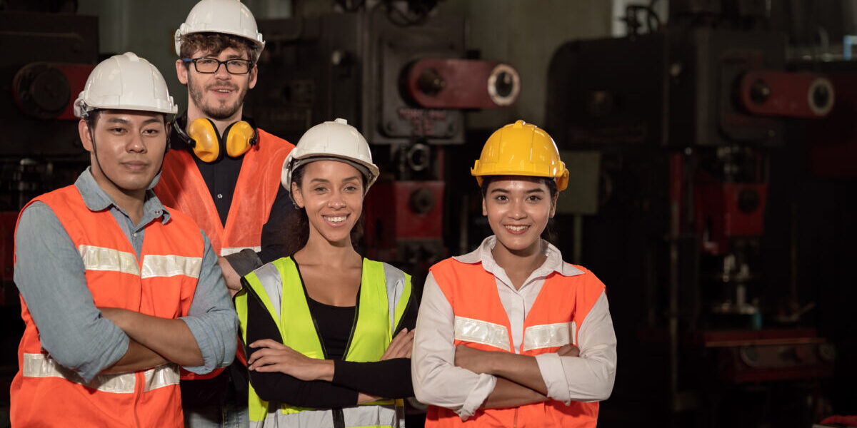 Group of Team Worker mix race  enjoy working in heavy factory standing together happy smiling